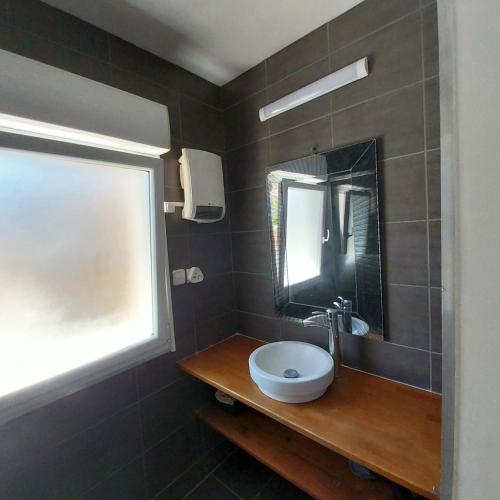 une salle de bain avec un lavabo et un miroir dans l'établissement Coquette maison, 2 chambres mansardées, Narbonne Plage, à Narbonne-Plage