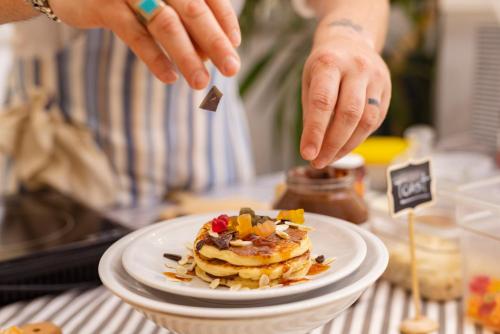 Hotel Mauritius Sentirsi come a Casa في ريتشيوني: شخص يقدم طبقًا من الطعام على الطاولة