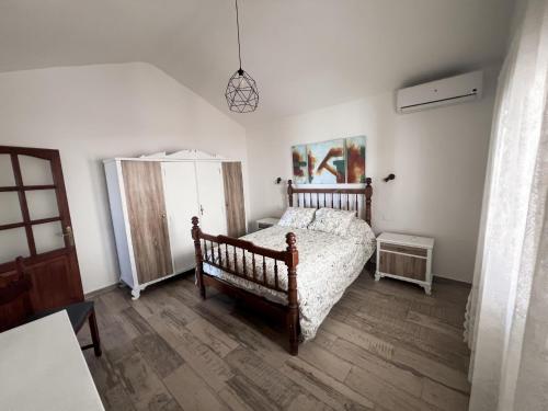 ein Schlafzimmer mit einem Bett und einem Holzboden in der Unterkunft Vivelorural Abuela María 2, a place for families in San Bartolomé de Tirajana