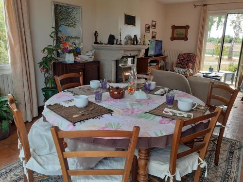une table de salle à manger avec une nappe dessus dans l'établissement Chambres chez l habitant, à Langrolay