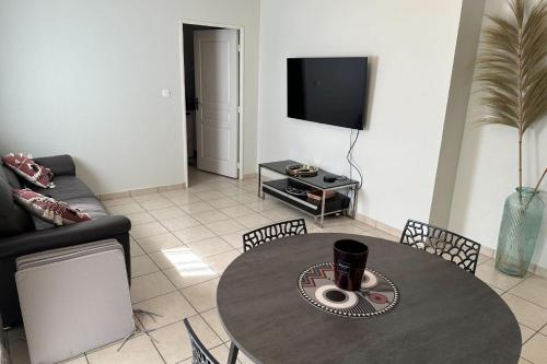 un salon avec une table et une télévision dans l'établissement Apartment in Croix des Gardes, à Cannes