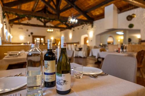 two bottles of wine on a table in a restaurant at Hotel Stalon Alpine Chic in San Martino di Castrozza