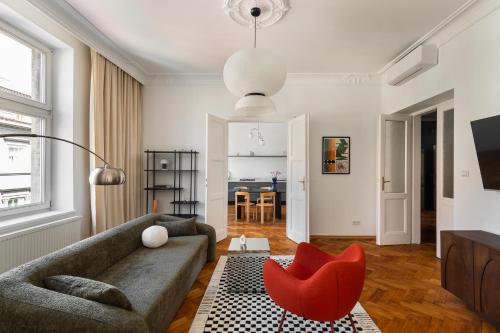 a living room with a couch and a red chair at St Florian Apartments in Kraków