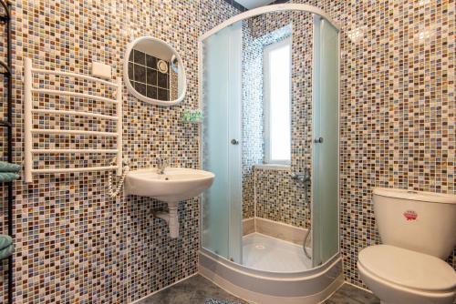 a bathroom with a toilet and a sink and a shower at Birutės Vila in Palanga