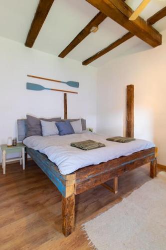 a large bed in a room with wooden floors at Tulipános Porta in Sarud