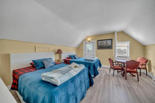 a bedroom with two beds and a table and chairs at Marmora and Lake Inn Superior Apartment- Sleeps 13 guests in Marmora