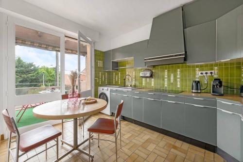une cuisine avec une table, des chaises et un évier dans l'établissement L'Élégance Urbaine-clim-parking gratuit dans rue, à Toulouse