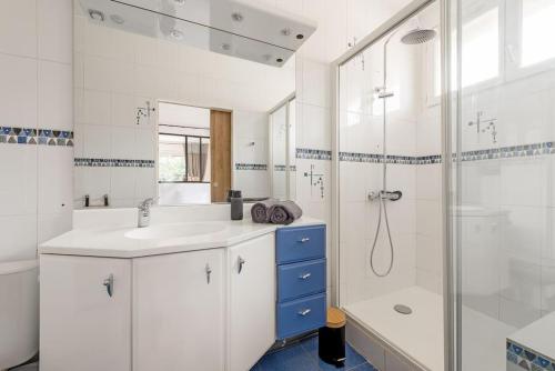 une salle de bain blanche avec un lavabo et une douche dans l'établissement L'Élégance Urbaine-clim-parking gratuit dans rue, à Toulouse