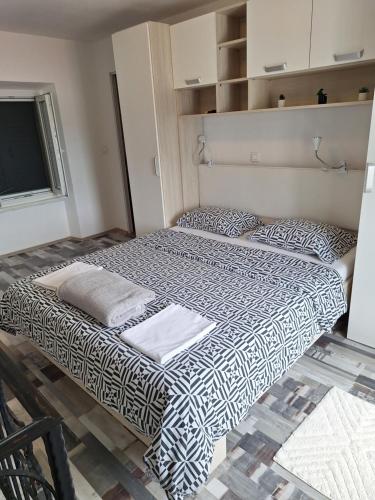 Cama grande en habitación con ventana en Makol en Primošten