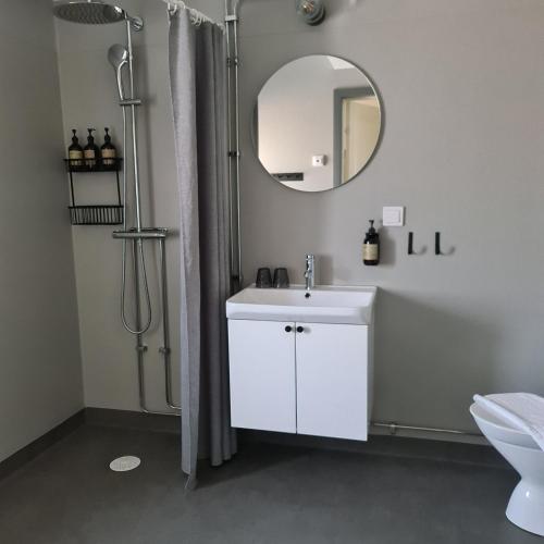 a bathroom with a white sink and a mirror at Gumbalde Resort in Stånga