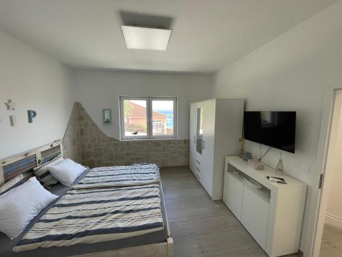 a bedroom with a bed and a flat screen tv at Villa SeaBreeze in Kali