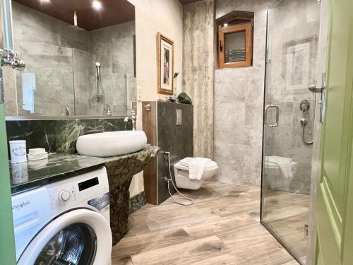 uma casa de banho com uma máquina de lavar roupa e um chuveiro em T2&T3 Apartments LEVANTO em Tbilisi