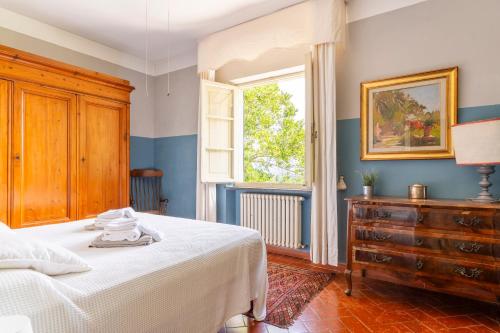 Fattoria Laviosa في Fauglia: غرفة نوم مع سرير وخزانة ونافذة