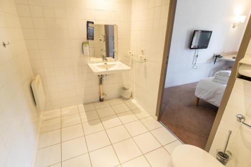 uma casa de banho com um lavatório e um WC em Kyriad Direct Auxerre - Appoigny em Appoigny