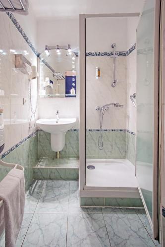 une salle de bain avec douche et lavabo dans l'établissement Azur Hôtel, à Balaruc-les-Bains
