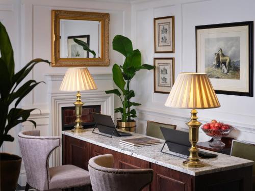 a room with a desk with two lamps and chairs at The Chelsea Townhouse by Iconic Luxury Hotels in London