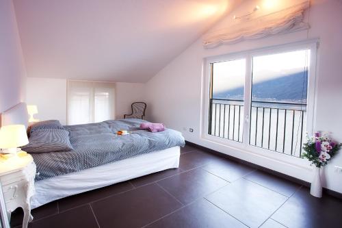a bedroom with a bed and a large window at Colonno Apartment in Sala Comacina