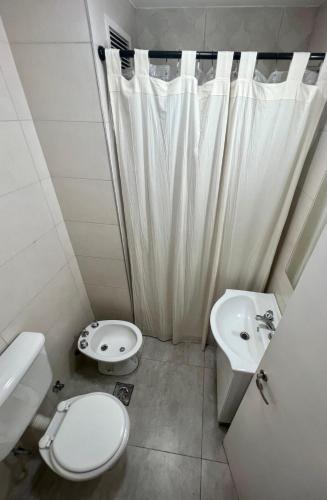 a white bathroom with a toilet and a sink at Japandi San Juan in San Juan
