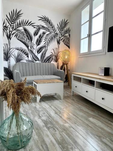 - un salon avec un canapé et un mur de plantes dans l'établissement Cozy studio completely renovated with breathtaking views of the port, à Saint-Martin-de-Ré