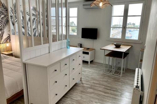 - une chambre avec une commode blanche et un bureau dans l'établissement Cozy studio completely renovated with breathtaking views of the port, à Saint-Martin-de-Ré