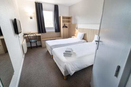 a hotel room with two beds and a mirror at Kyriad Direct Auxerre - Appoigny in Appoigny