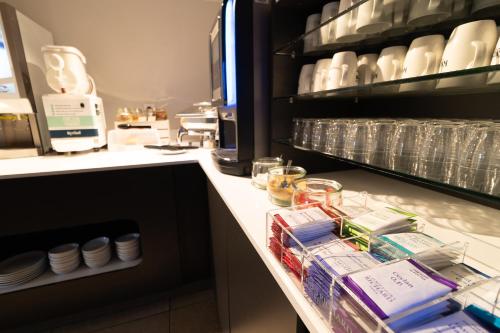 a counter in a kitchen with plates and glasses at Kyriad Direct Auxerre - Appoigny in Appoigny