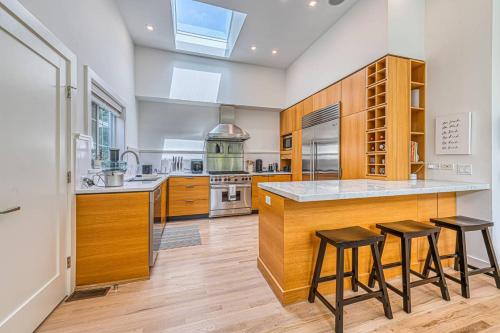 a kitchen with wooden cabinets and a counter with stools at Villa Vajra in East Hampton