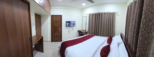 a bedroom with a bed and a television in it at Hotel NJ RESIDENCY NEAR DLF IT PARK, RMZ SOFTWARE PARK, L&T ECC, CHENNAI TRADE CENTRE & MIOT in Chennai