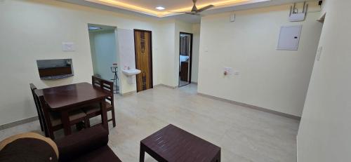 a living room with a table and a couch and a television at Hotel NJ RESIDENCY NEAR DLF IT PARK, RMZ SOFTWARE PARK, L&T ECC, CHENNAI TRADE CENTRE & MIOT in Chennai