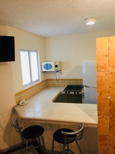 a small kitchen with a stove and a refrigerator at Angeles Suites & Hotel in Veracruz