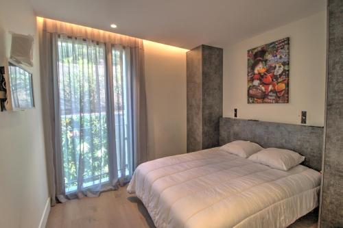 une chambre avec un grand lit et une grande fenêtre dans l'établissement Blue Diamond - 8 personnes - 5*, aux Issambres