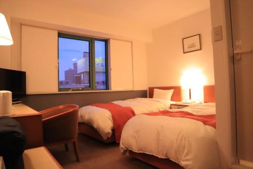 青森的住宿－Aomori Green Park Hotel Annex，酒店客房设有两张床和窗户。