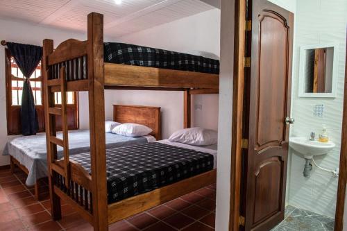a bedroom with two bunk beds and a bathroom at Hostal Café Racer in Jardin