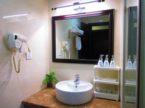 baño con lavabo, teléfono y espejo en MAY PLAZA HOTEL, en Thái Nguyên
