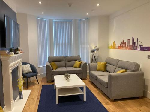 a living room with two couches and a fireplace at Exceptional 5 bed house near City Centre in Liverpool