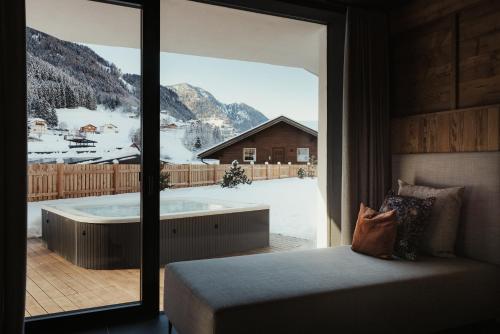 a bedroom with a view of a tub with a mountain at Luxury Chalet Milé in Ortisei