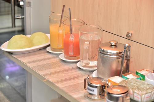 a counter with glasses of juice and bread on it at Hotel Buriti Stop in Goiânia
