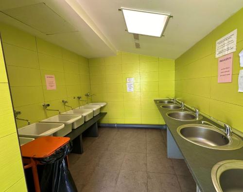 uma casa de banho com uma fila de lavatórios e uma fila de urinóis em Hostel Backpacker SOLOPUENT 3000 em Castiello de Jaca