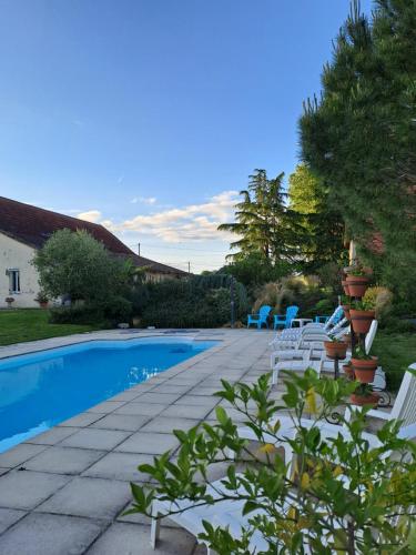 un patio con sillas y una piscina en La Garenne en Virazeil