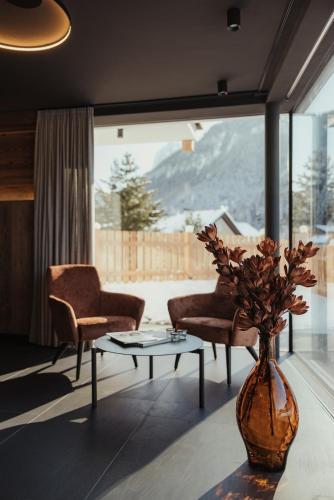 a living room with a table and a vase with flowers at Luxury Chalet Milé in Ortisei