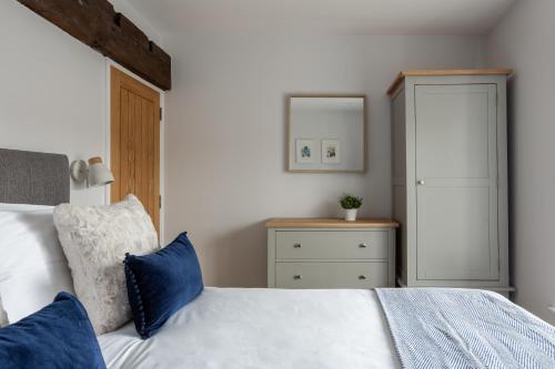 - une chambre avec un lit blanc et des oreillers bleus dans l'établissement Luxury Apartment Woodsmill View - on the river - with balcony - Recently refurbished, à York