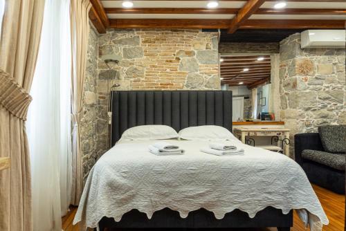 a bedroom with a large bed with a stone wall at Villa Domina in Split