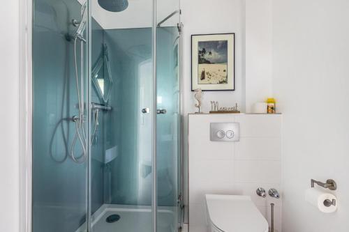 a bathroom with a glass shower and a sink at Rømø in Galmsbüll