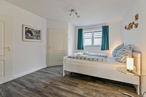 a bedroom with a large bed with blue curtains at Amrum in Galmsbüll