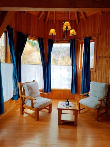 a living room with two chairs and a table at Apart Hotel del Pellin in San Martín de los Andes