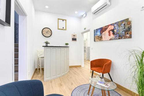 a living room with a chair and a clock on the wall at Casa Maya in Porto