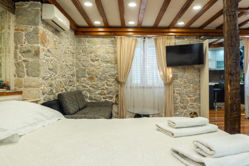 a bedroom with a bed and a chair and a television at Villa Domina in Split