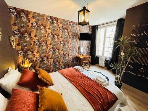 a bedroom with a large bed with a floral wallpaper at L'Etape Prestige in Reims