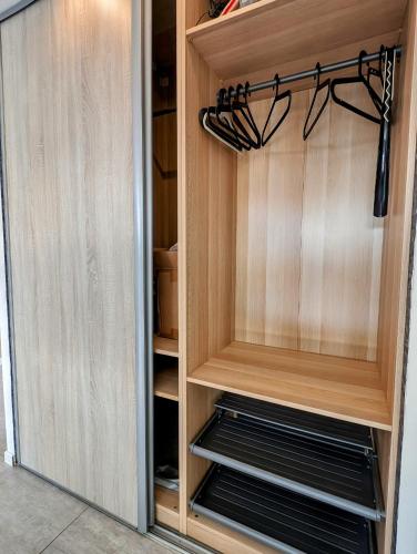 a closet with wooden cabinets and black shelves at La Chataigneraie in Châtenois