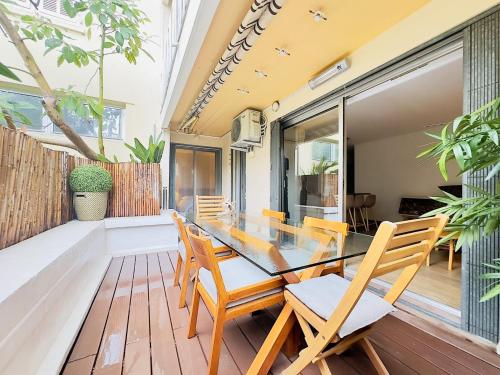 une salle à manger avec une table et des chaises sur une terrasse dans l'établissement L'ébène - Cannes Centre - Cozy, à Cannes